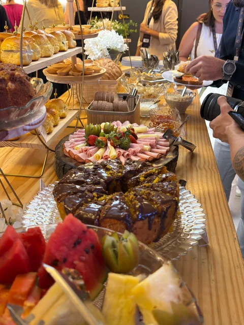 Mesa de coffee break com bolos, frutas e frios durante o serviço aos convidados