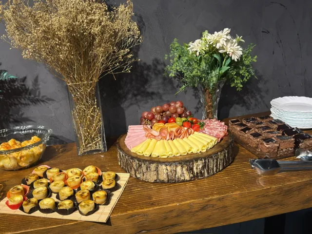 Mesa de buffet com queijos, frios e mini tortas